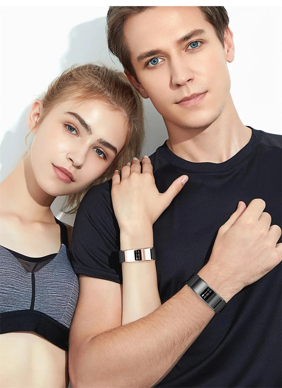 Wrist-worn fitness tracker bracelets on two people, gold-toned and dark straps