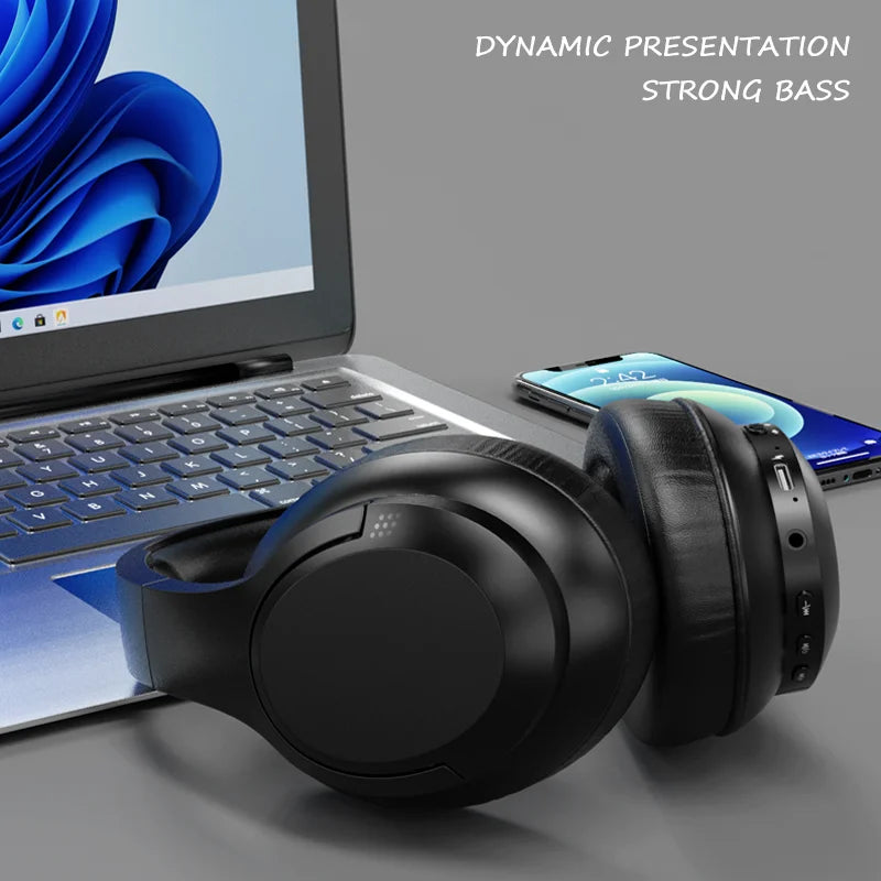Black over-ear wireless headset resting on a laptop keyboard with padded cushions