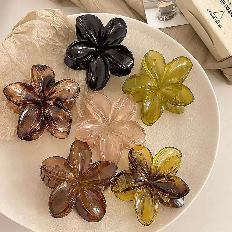 Hawaiian gradient flower hair claw clips assortment with black, amber, clear, and yellow flowers