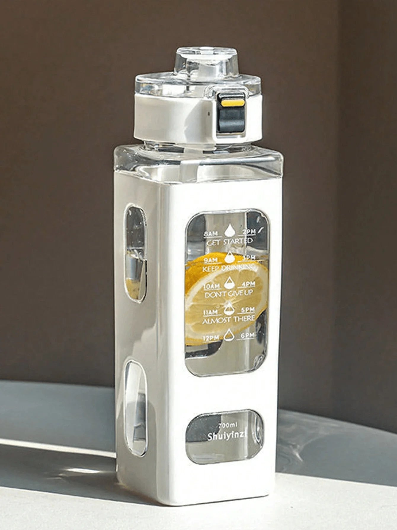 White sports water bottle with carry strap, flip-top lid, and translucent timetable window