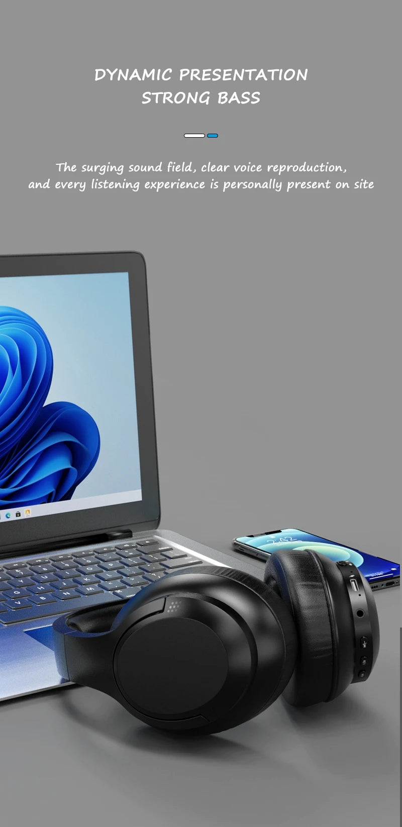 Black over-ear wireless headset on a desk beside a laptop