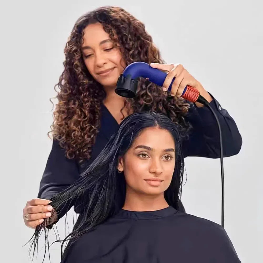 Blue hair dryer in use on long hair, with black nozzle attachment