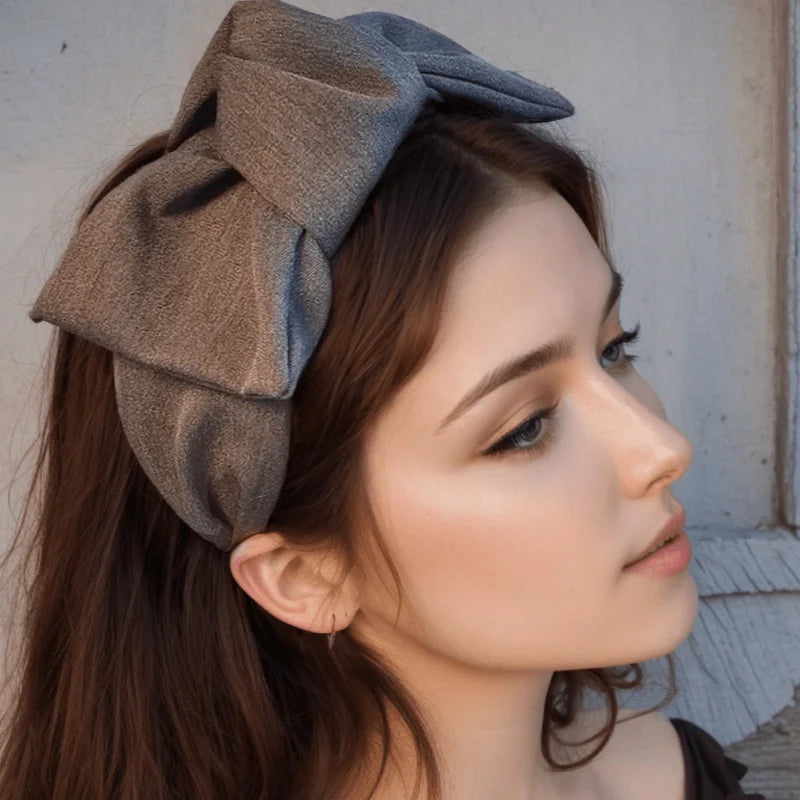 Grey wide bow headband with fabric knot, worn on hair side