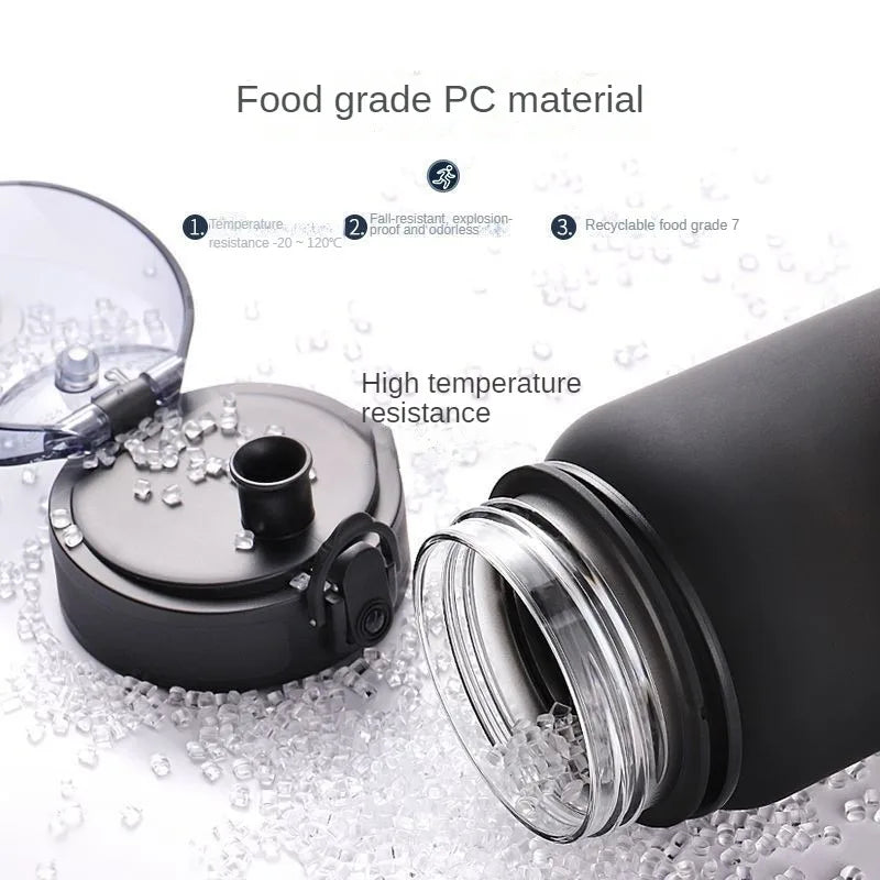 Sports water bottle with straw, black bottle and clear lid, shown with water splashes
