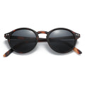 Round tortoiseshell sunglasses with dark lenses and slim curved temples