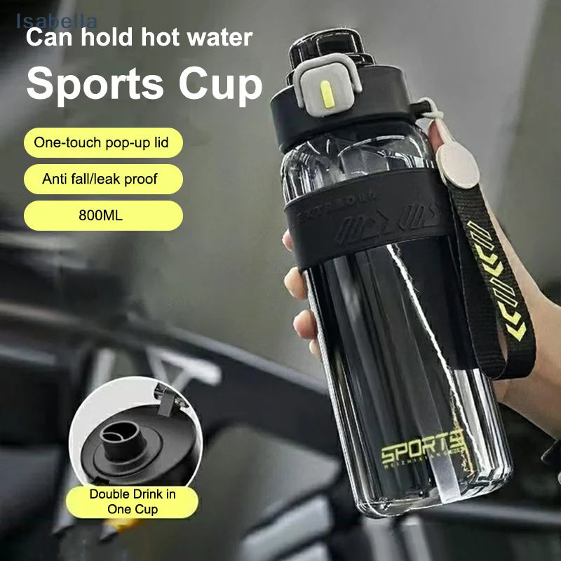 Black sports water bottle with pop-up lid and straw, held in hand with carry strap, 800 ml.