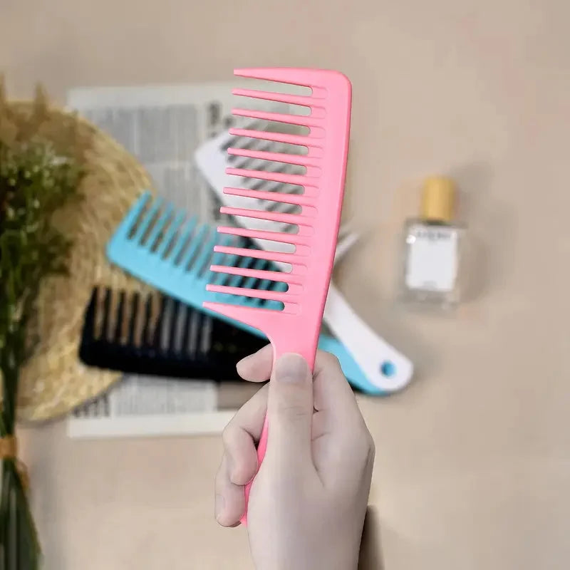 Pink wide-tooth comb in hand with large, evenly spaced teeth