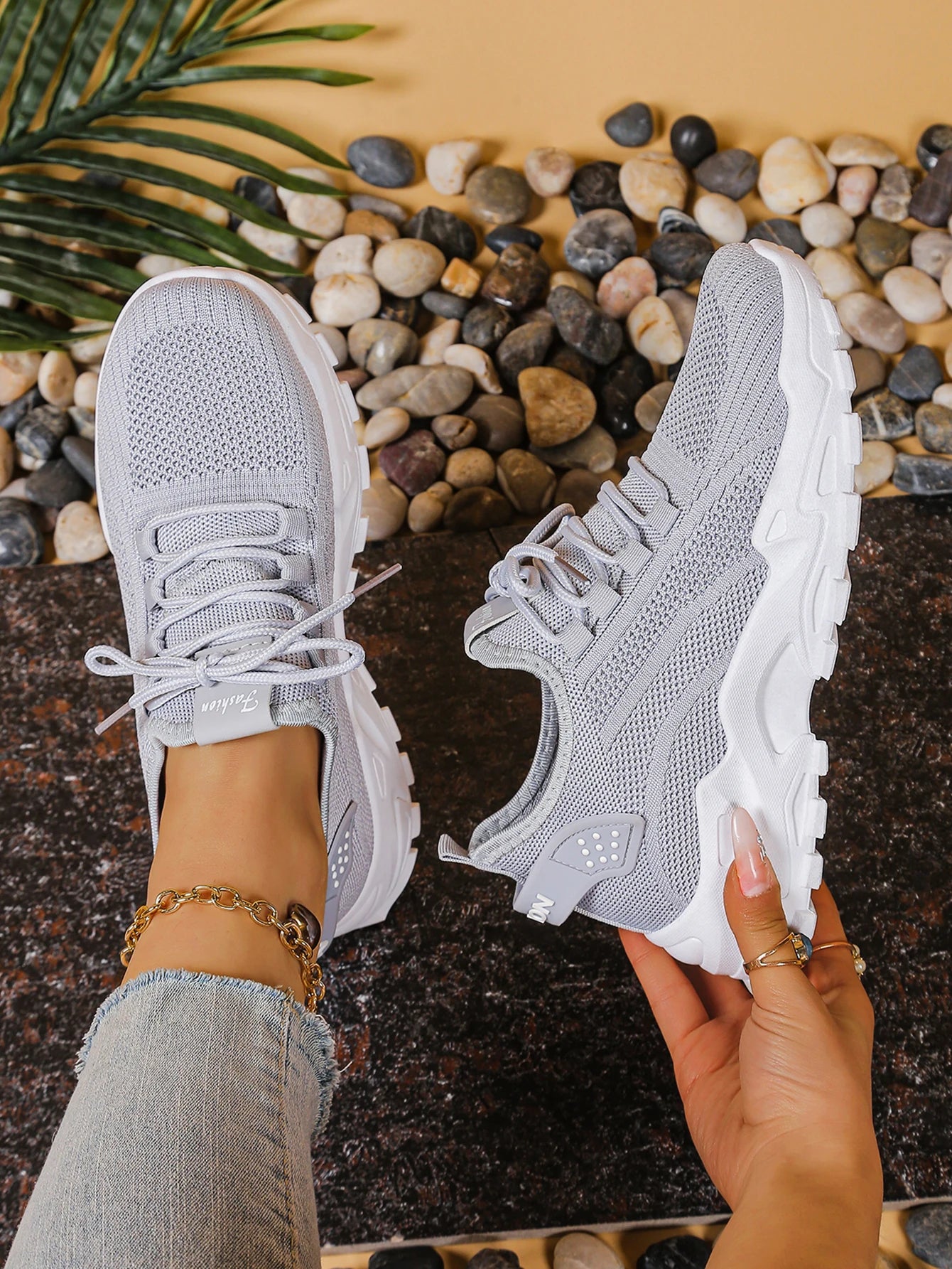 Pair of women's breathable mesh athletic sneakers with thick white soles in light gray