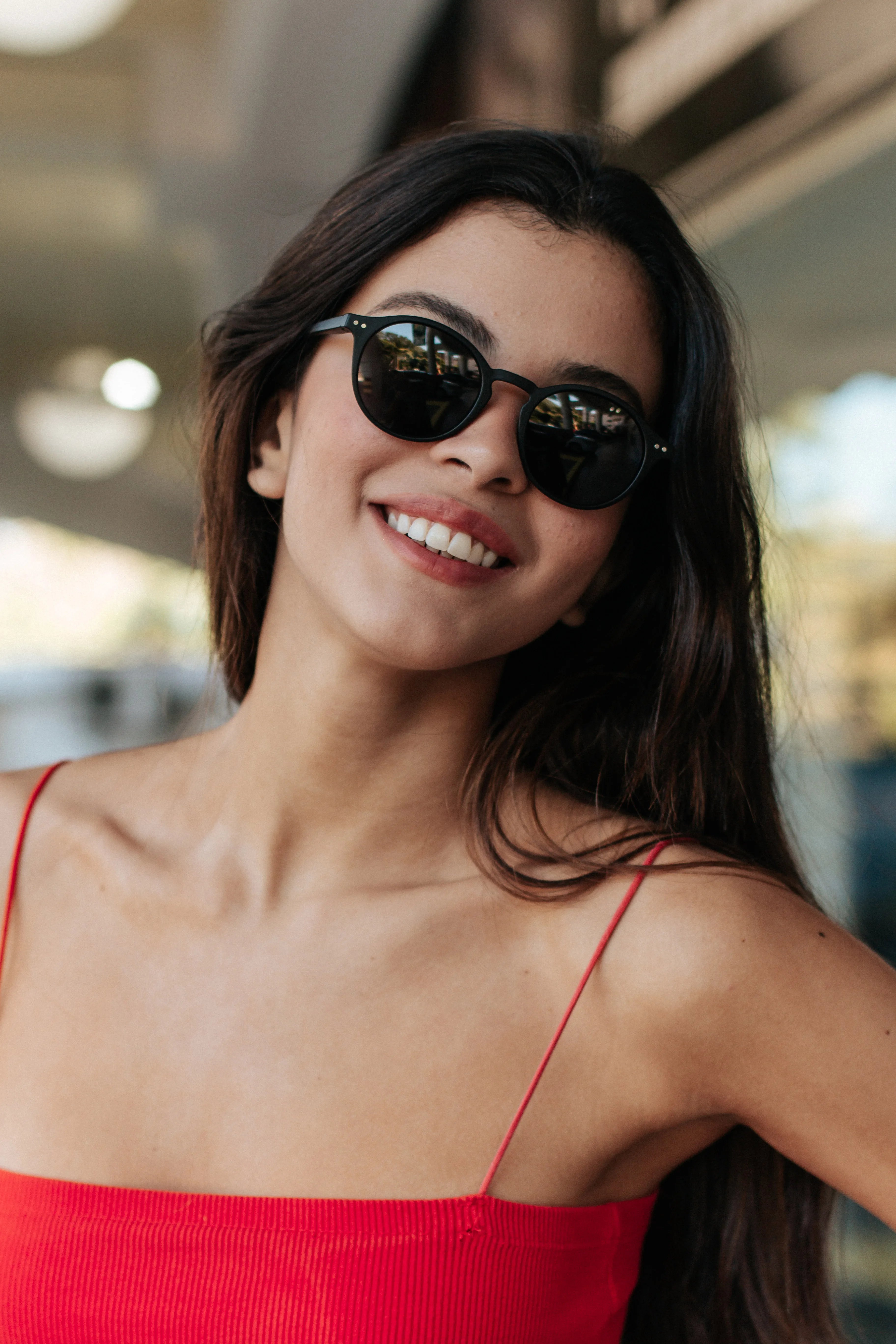 Round black sunglasses with dark lenses on smiling woman