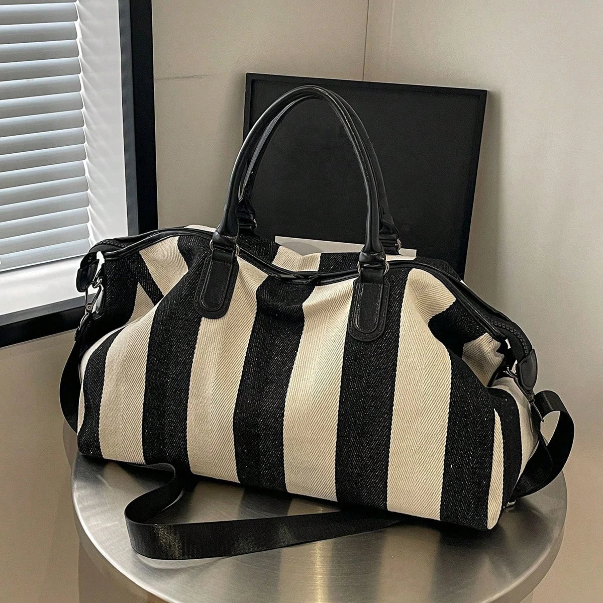 Large striped weekender duffle bag with top handles and adjustable shoulder strap