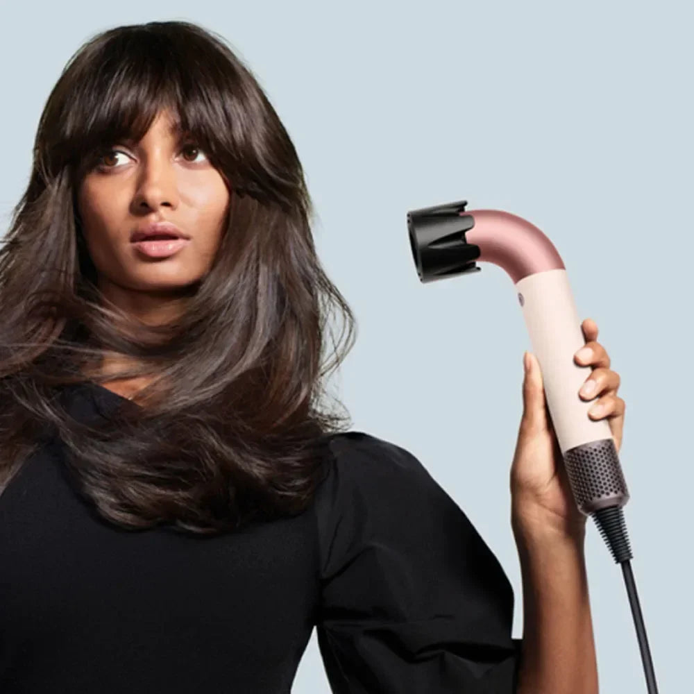 Rose pink hair dryer blowing on long dark hair