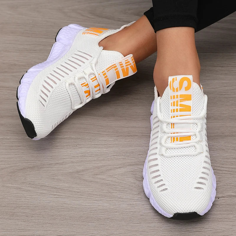 Women’s lightweight running shoes, white knit upper with orange strap closure and white sole