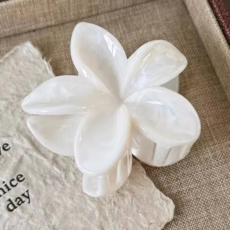 White translucent flower hair claw clip with five rounded glossy petals