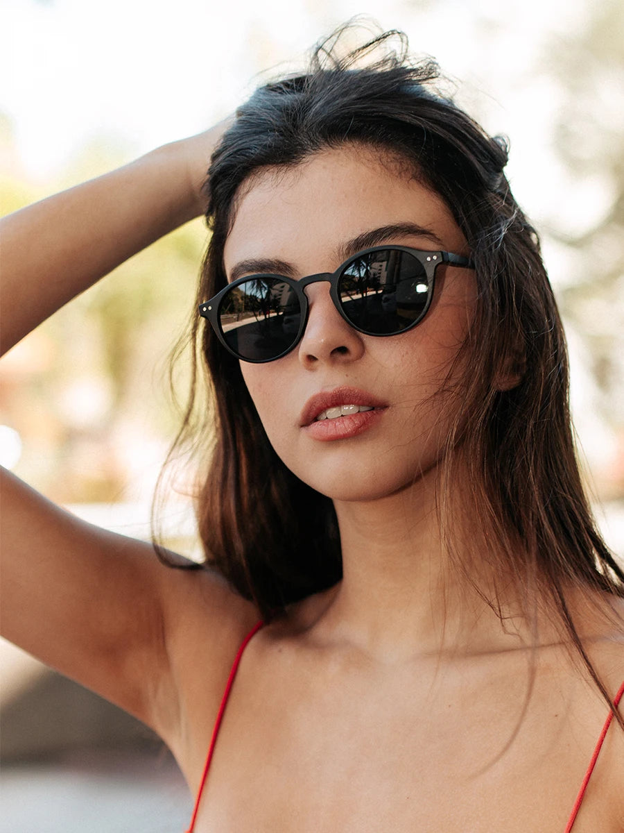 Round black sunglasses with dark polarized lenses and slim temples