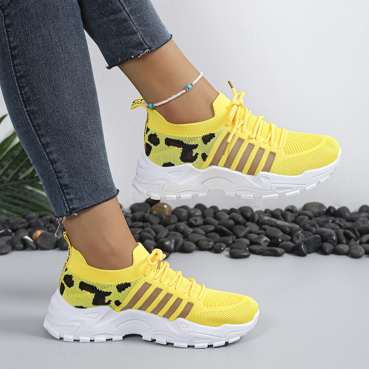 Pair of Cedar & Moore yellow leopard print athletic sneakers with breathable knit upper and thick white sole