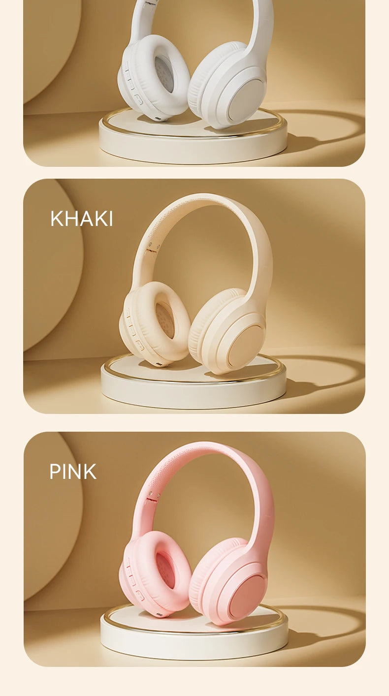 Over-ear wireless Bluetooth headphones in khaki and pink on charging stands.