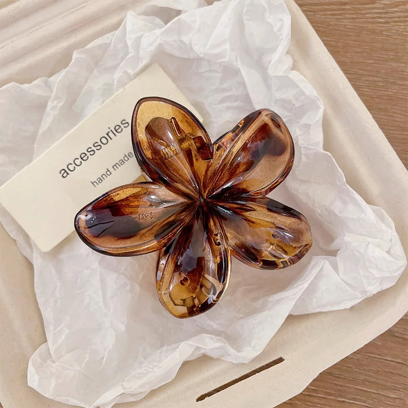 Hawaiian gradient flower hair claw clip with dark amber-brown translucent petals