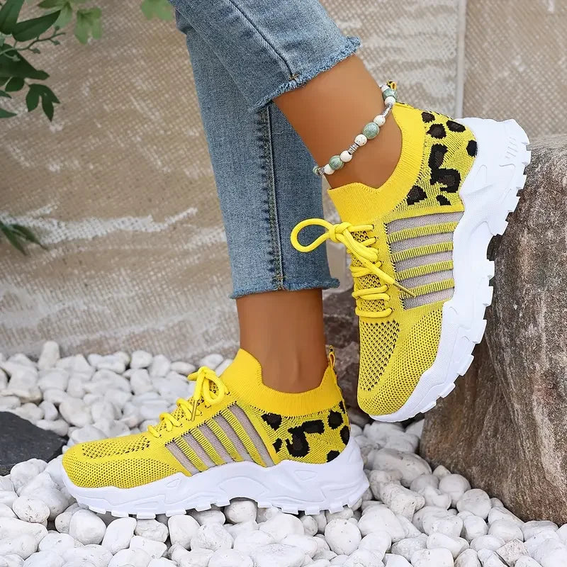 Women's leopard-print athletic sneakers in yellow with breathable knit upper and thick white sole.