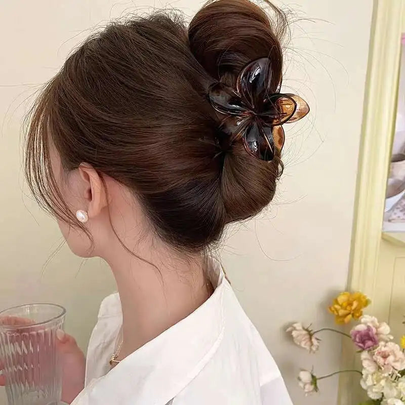 Dark brown flower hair claw clip with glossy petals and starburst center