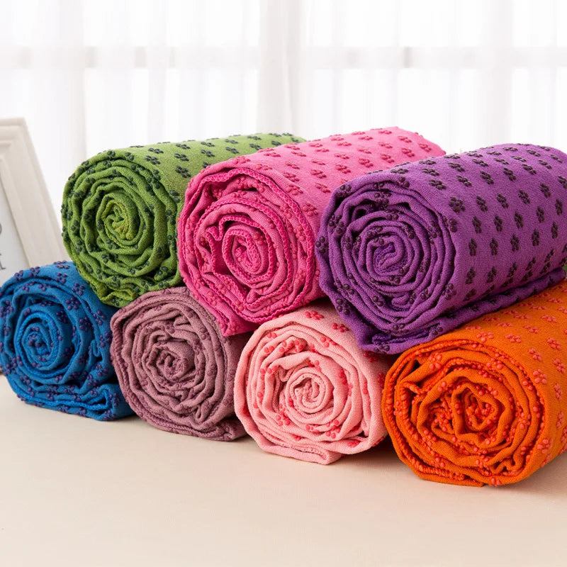 Non-Slip Yoga Towel Cedar & Moore, 7 colorful rolled towels in green, pink, purple, blue, taupe, peach and orange.