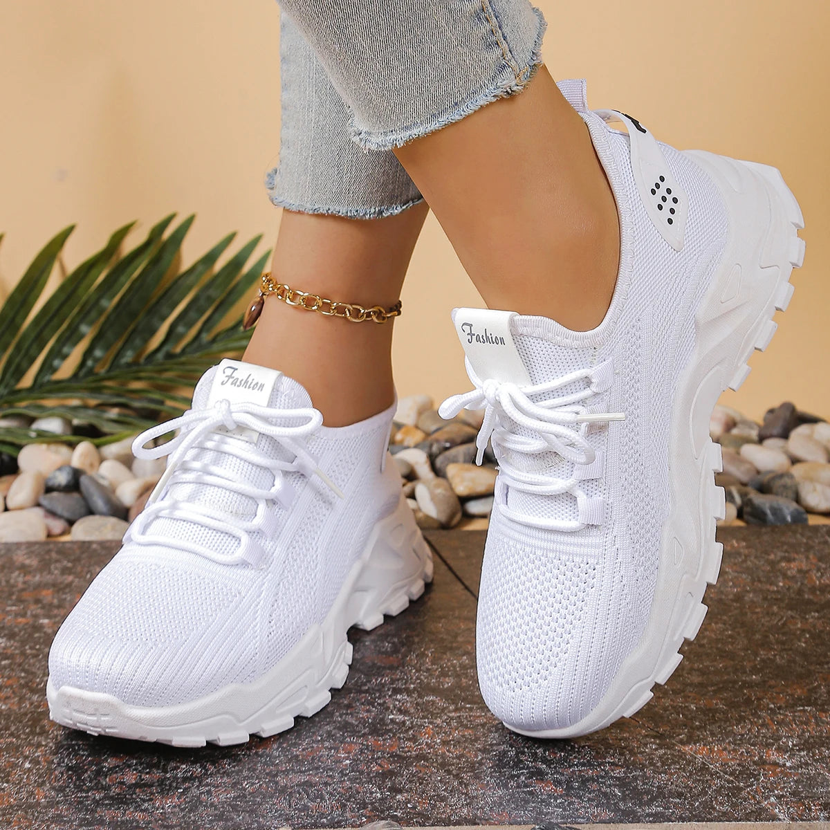 Two white women's breathable mesh athletic sneakers with thick soles
