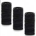 Black hair ties, rolled stack of small ponytail elastic bands