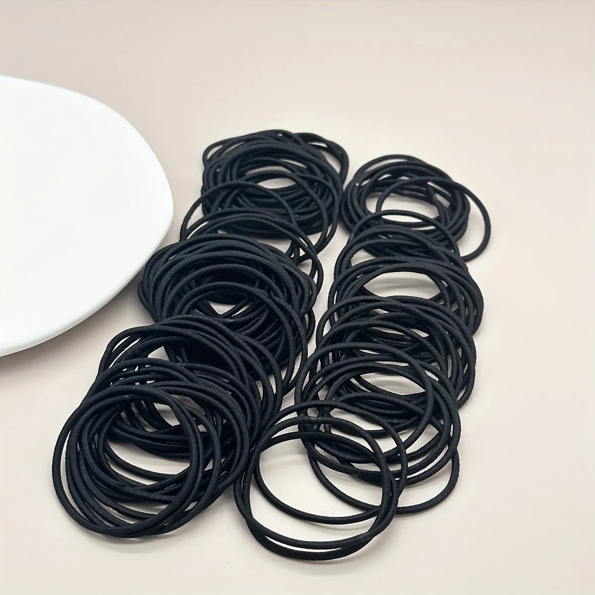 Black hair ties, grouped coils of elastic bands on tray