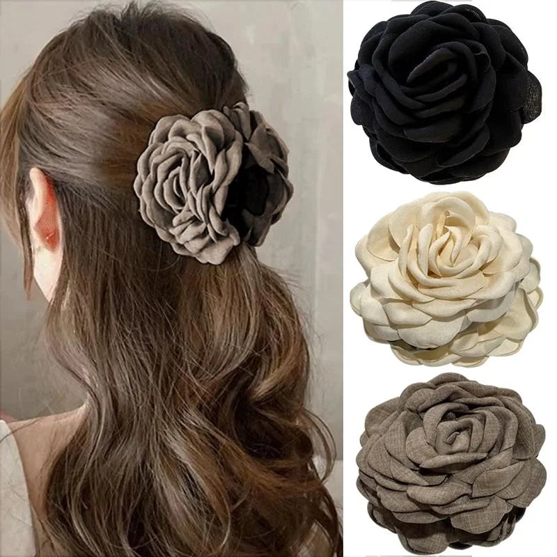 Gray fabric rose hair claw clip with layered petals on a barrette base