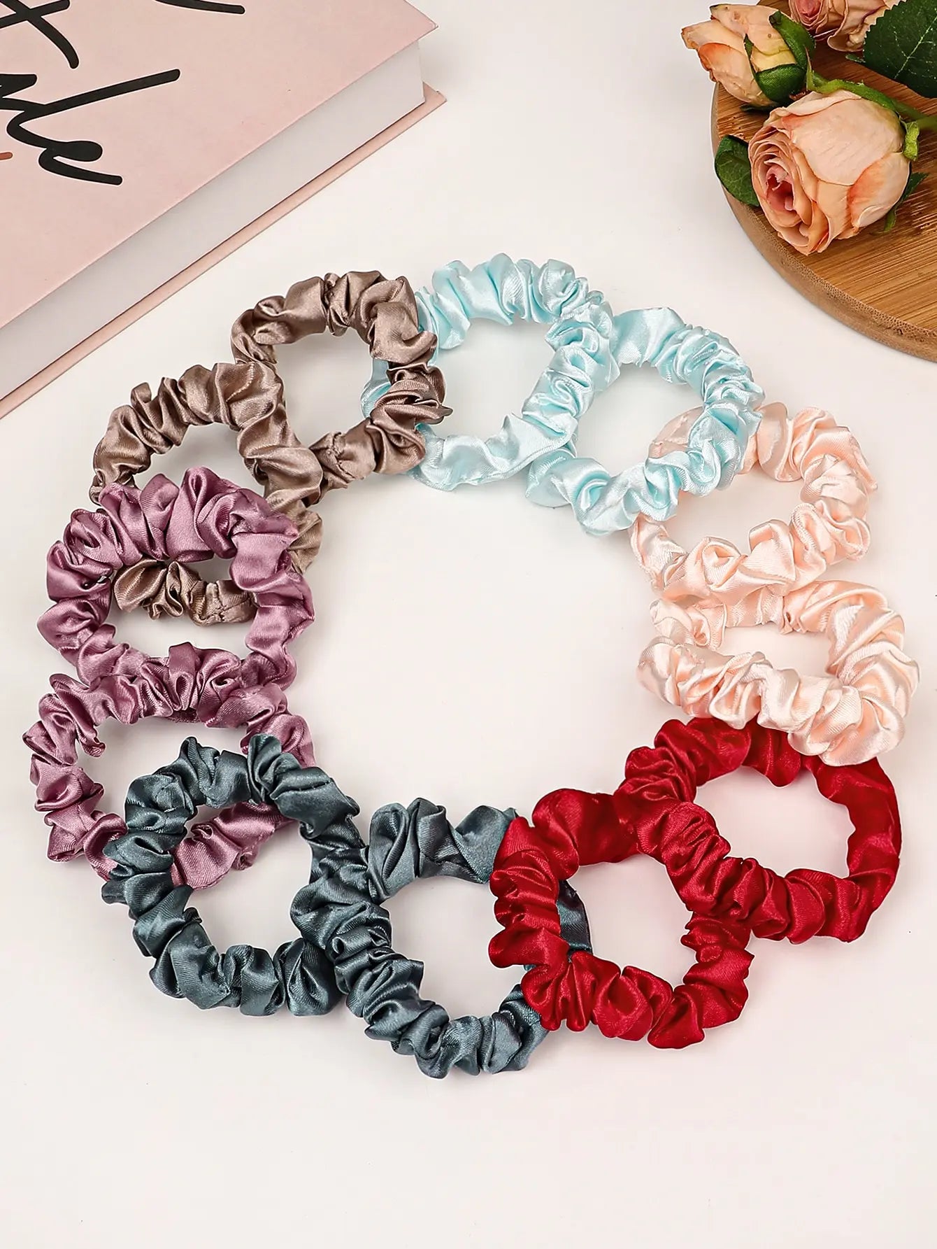 Small satin hair scrunchies assorted colors arranged in circular set, pastel and jewel tones