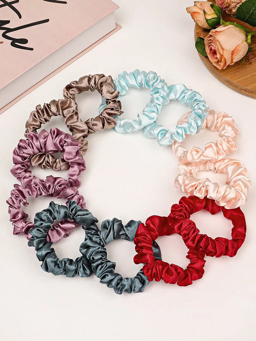 Small satin hair scrunchies assorted colors arranged in circular set, pastel and jewel tones