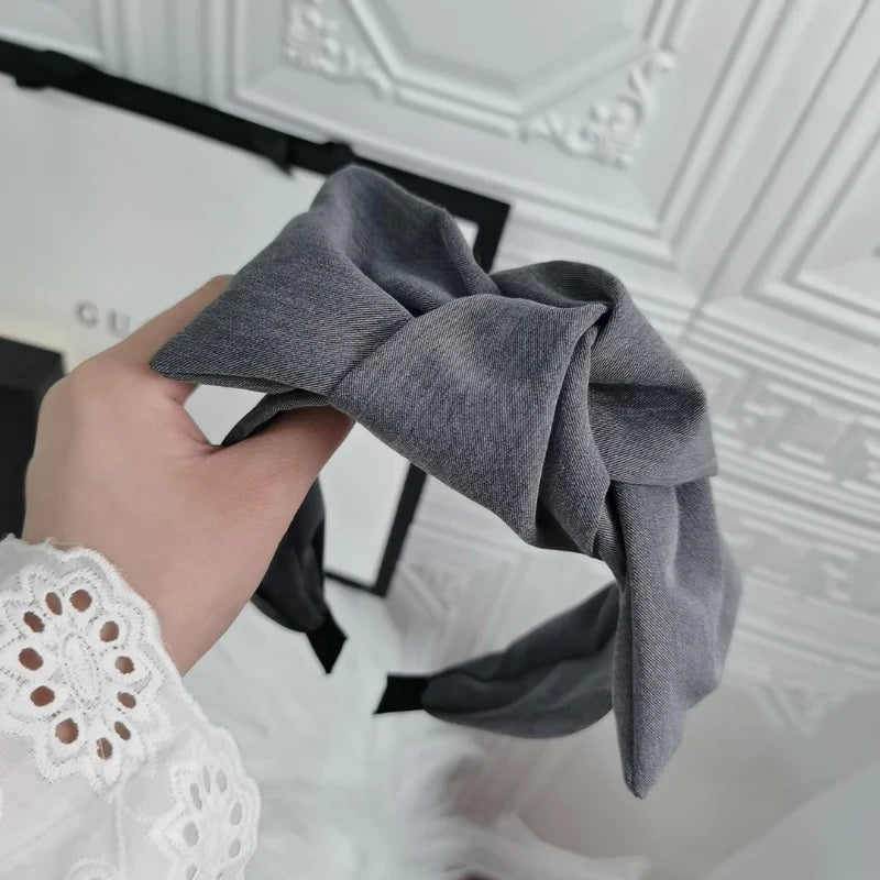 Grey wide bow headband with fabric knot, fabric folds visible
