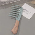 Light blue wide-tooth detangling comb with long prongs and beige handle, on card
