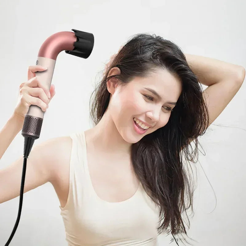 Pink and cream hair dryer in hand with concentrator nozzle, drying long dark hair