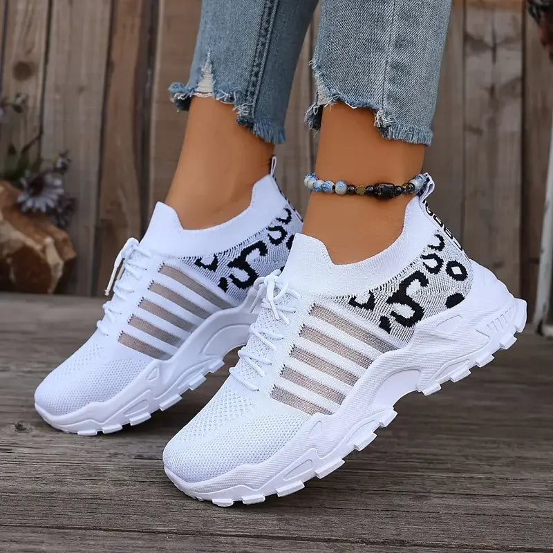 Pair of women's white leopard-print athletic sneakers with breathable mesh upper and thick cushioned sole