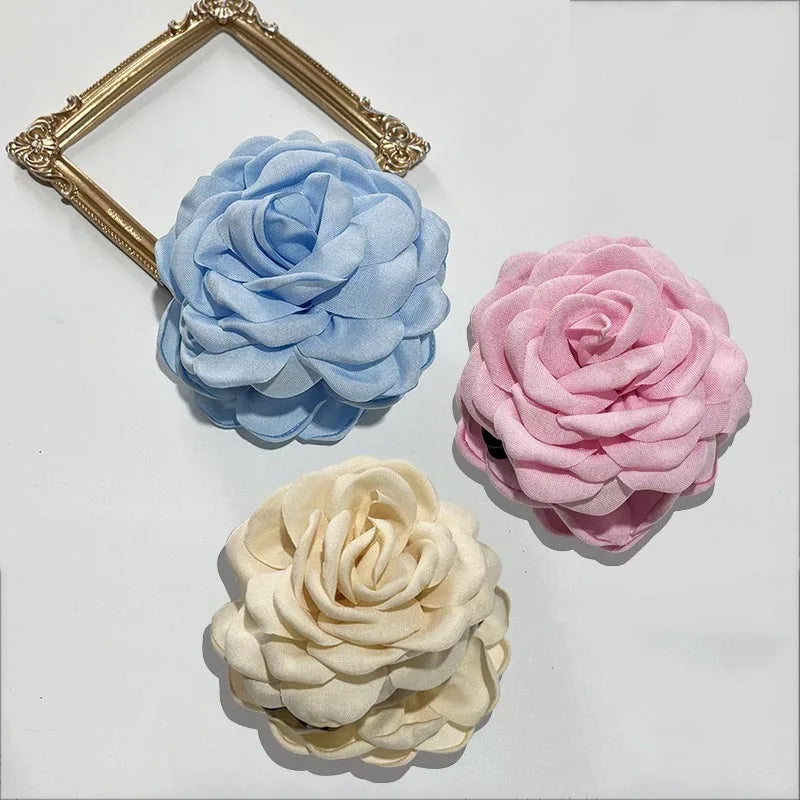 3-pack fabric rose hair claw clips in light blue, pink, and cream with claw bars