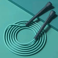 Teal speed jump rope with two handles and a coiled cable loop