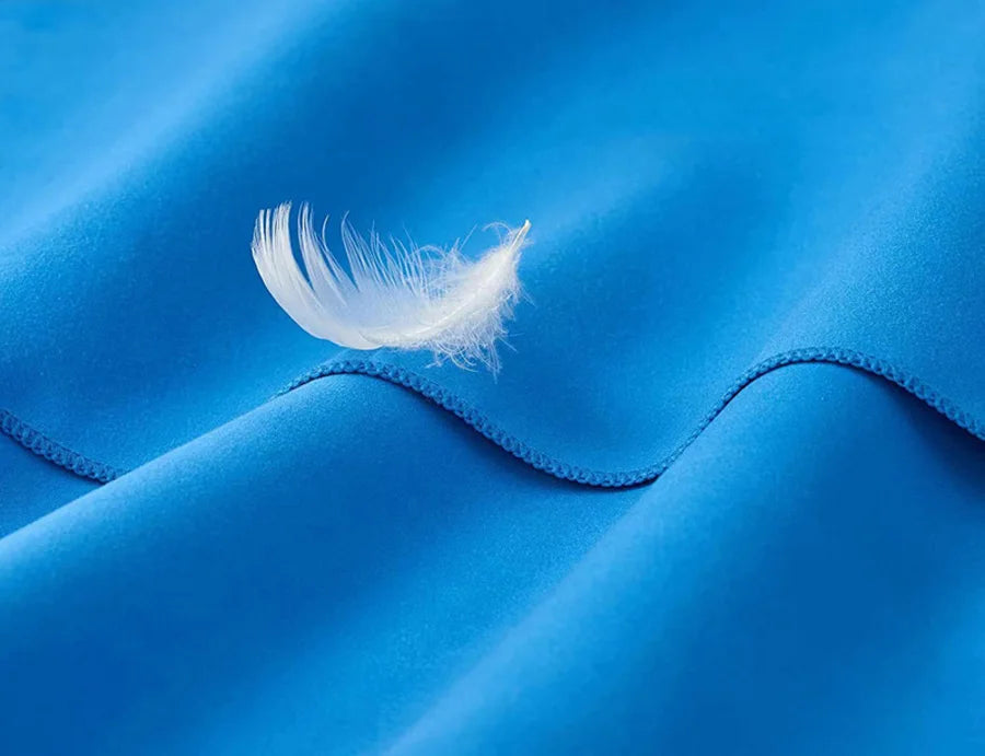 Microfiber towel in blue with a white feather and visible stitched edge