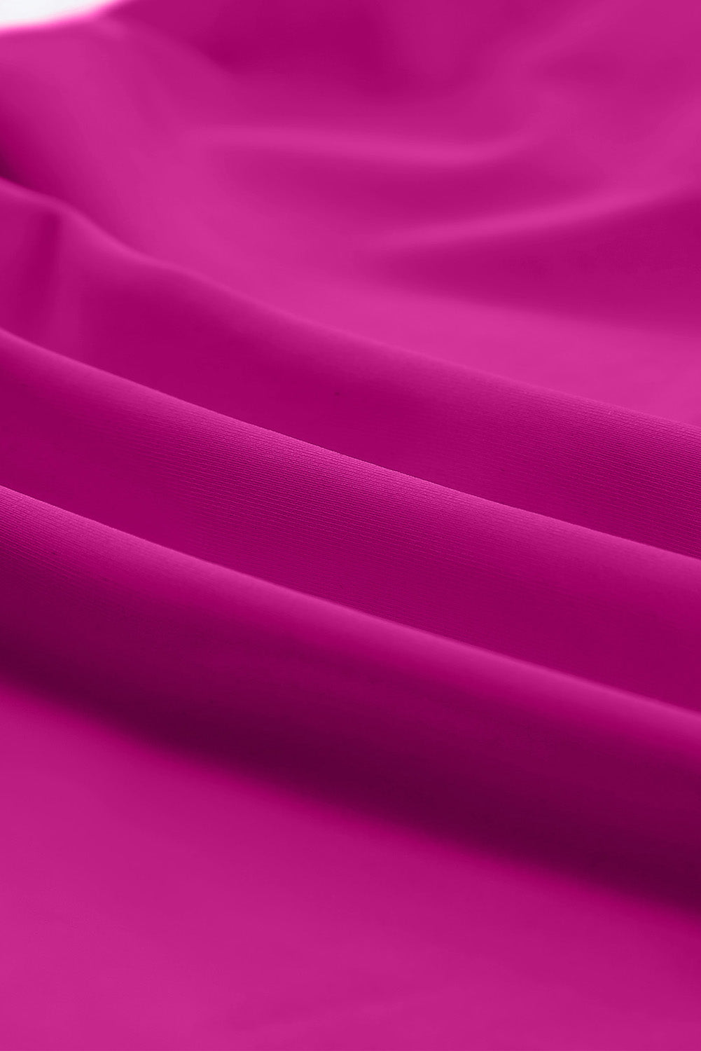 Ruched magenta tankini fabric with layered, gathered texture close-up