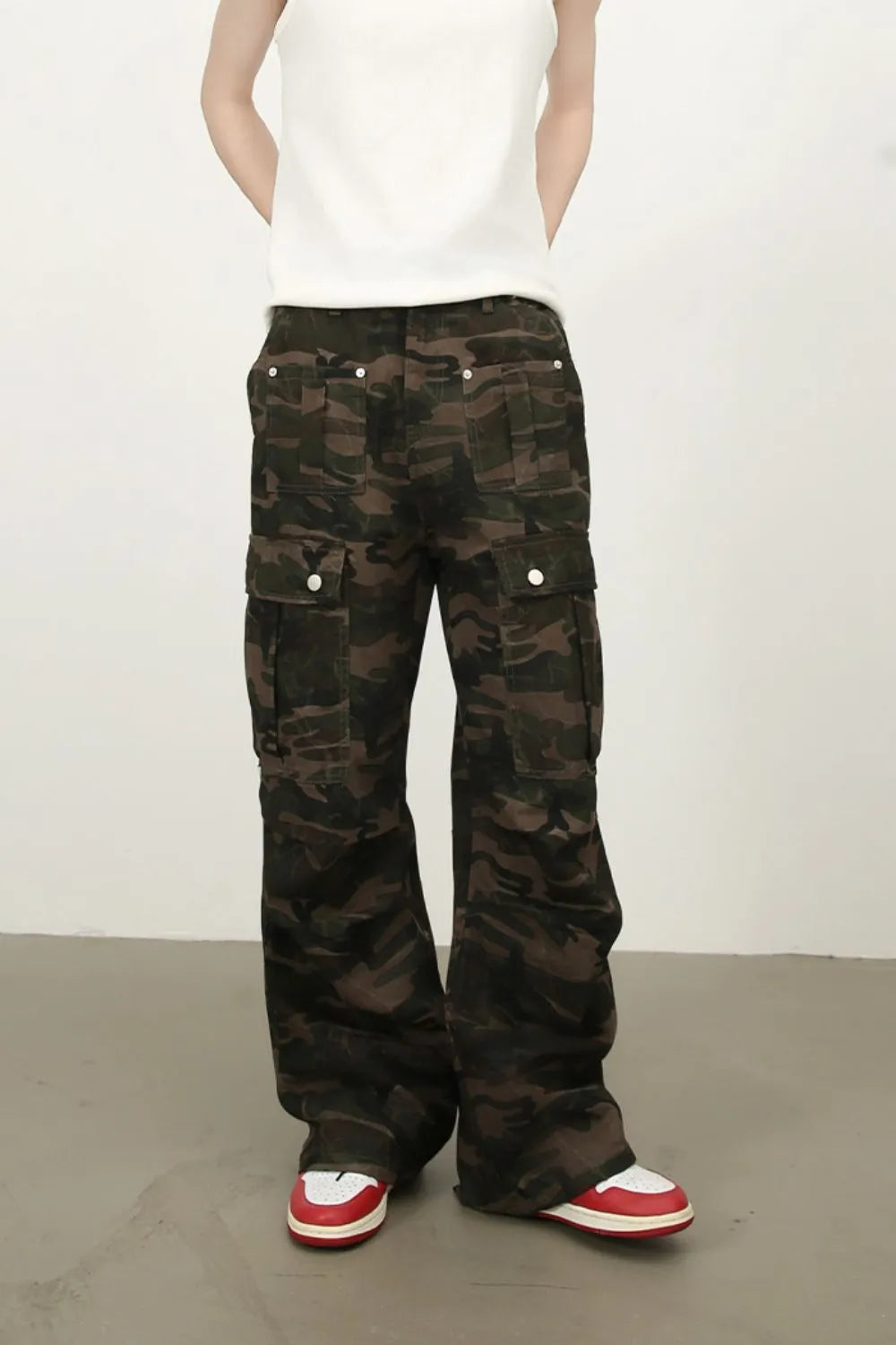 Men's green camouflage cargo jeans with wide leg opening and front flap cargo pockets