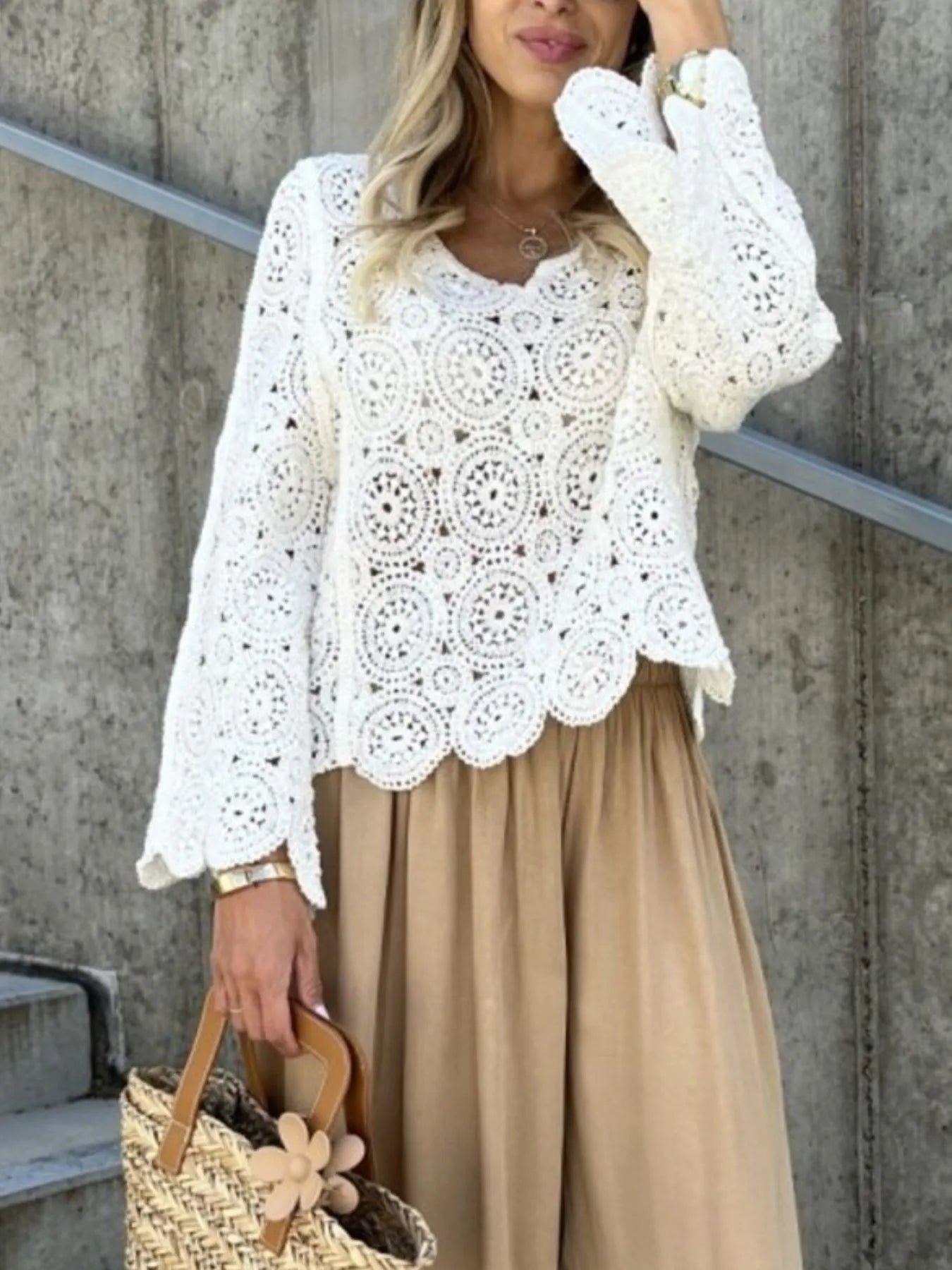 White crochet lace knit top with V-neckline, floral openwork, and flared sleeves