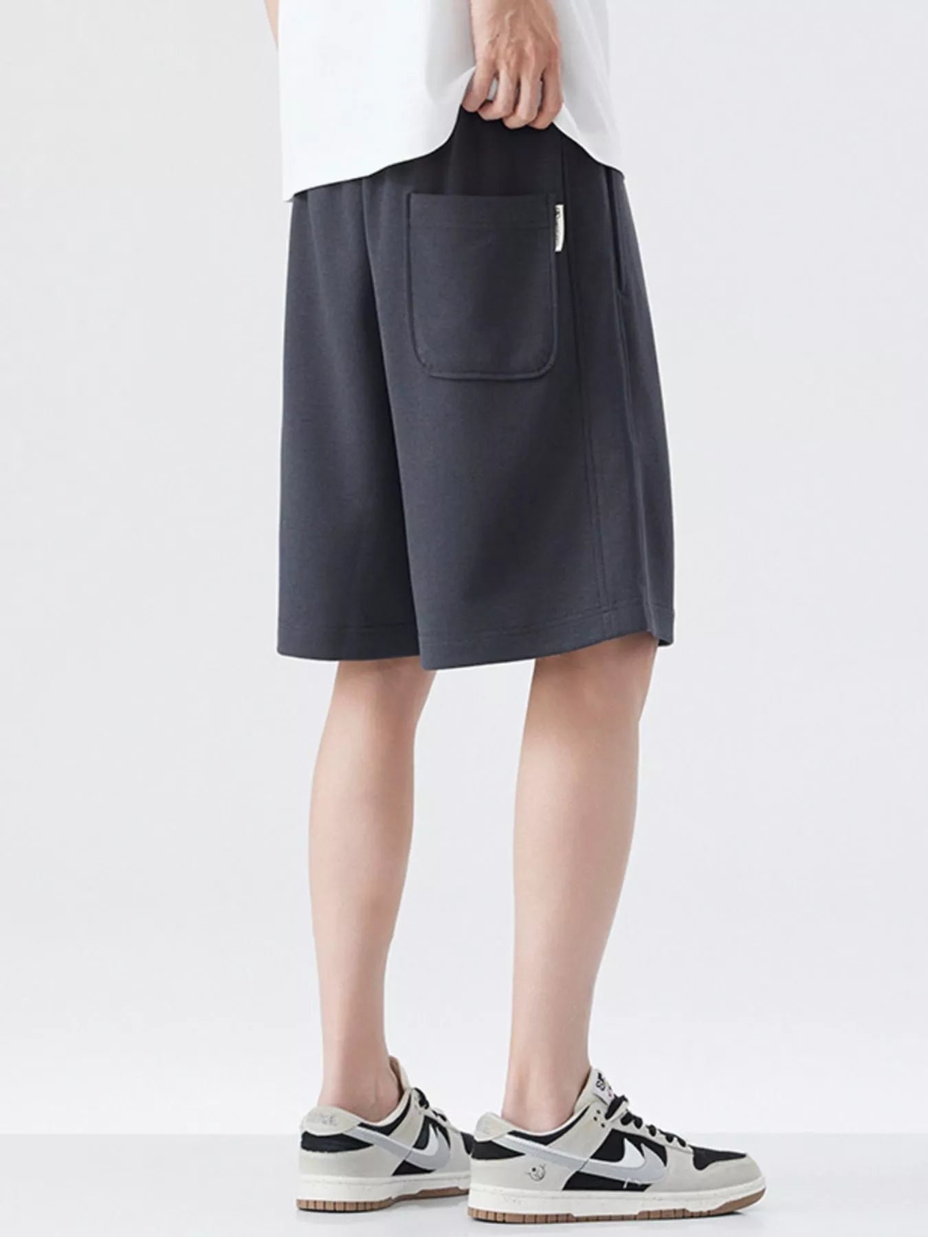 Dark gray drawstring loose-fit shorts with flap front pocket and straight leg