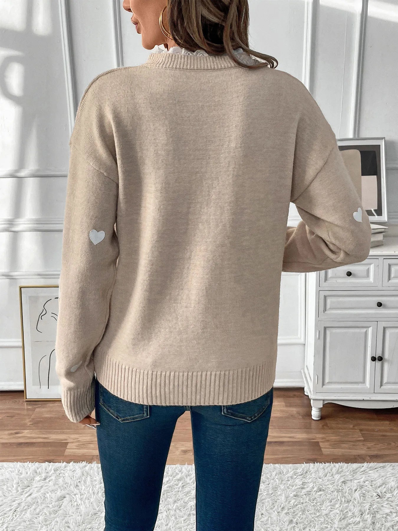 Light khaki long sleeve sweater with small heart patches on sleeves, back view