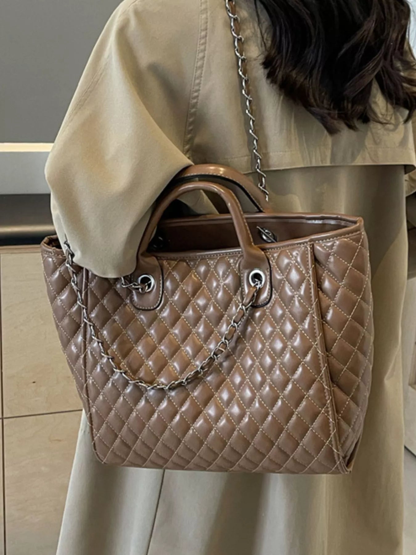 Brown quilted medium tote bag with chain shoulder strap and rounded top handles