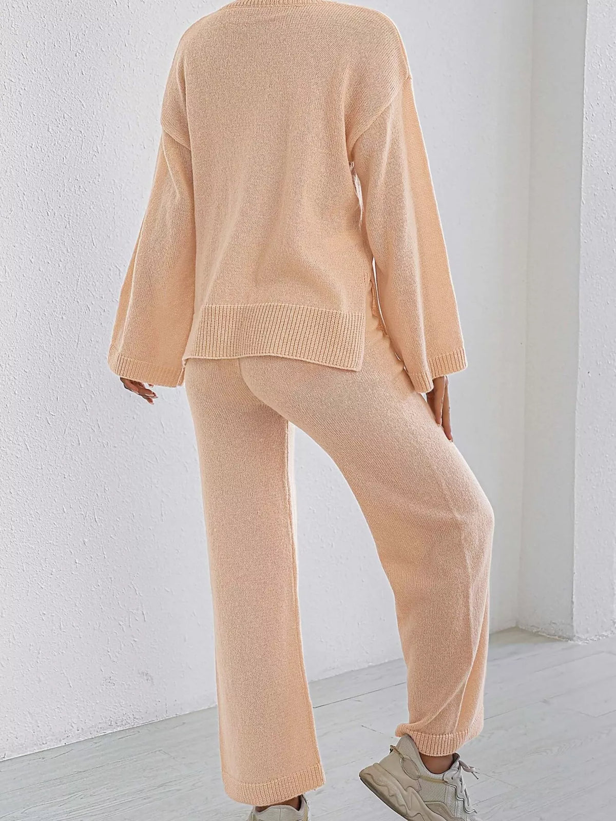 Apricot knit sweater and pants set, back view with dropped shoulders and ribbed leg cuffs.