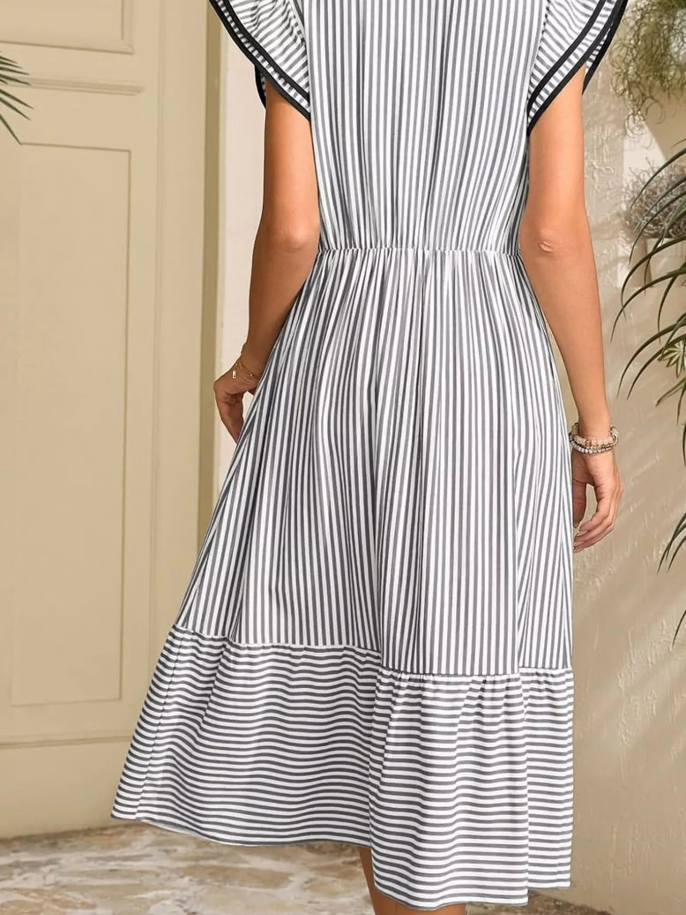 Striped Notched Ruffle Sleeve Dress with navy and white vertical stripes, pocketed waist, tiered hem.