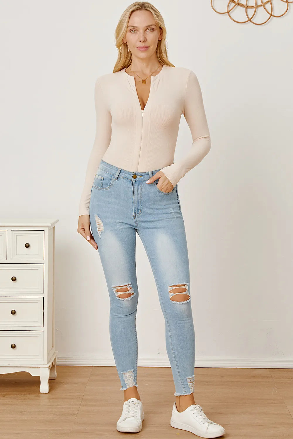 Tan zip-front long sleeve bodysuit with V neckline and fitted bodice