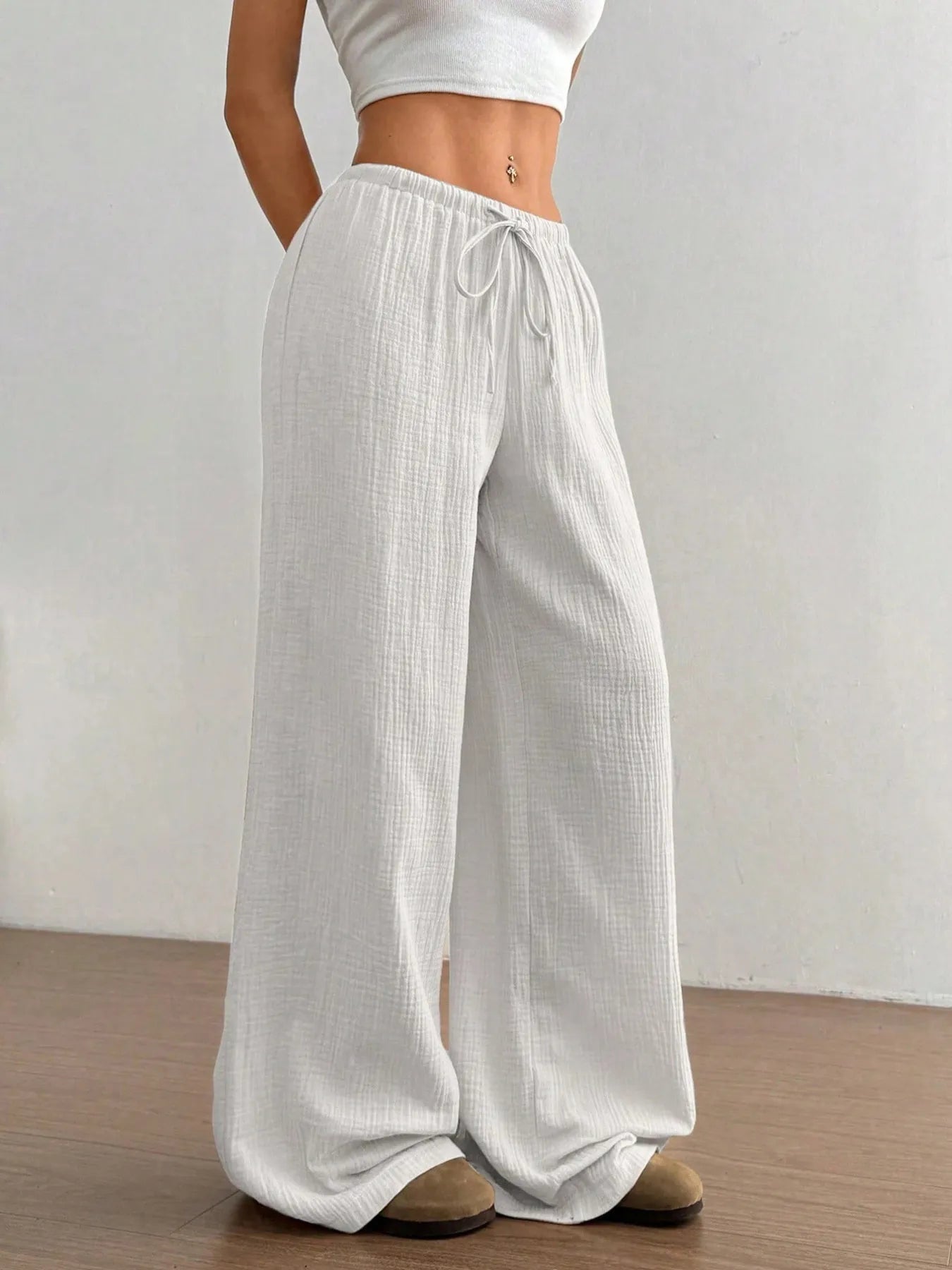 White wide-leg casual pants with elastic waistband and drawstring tie at front.