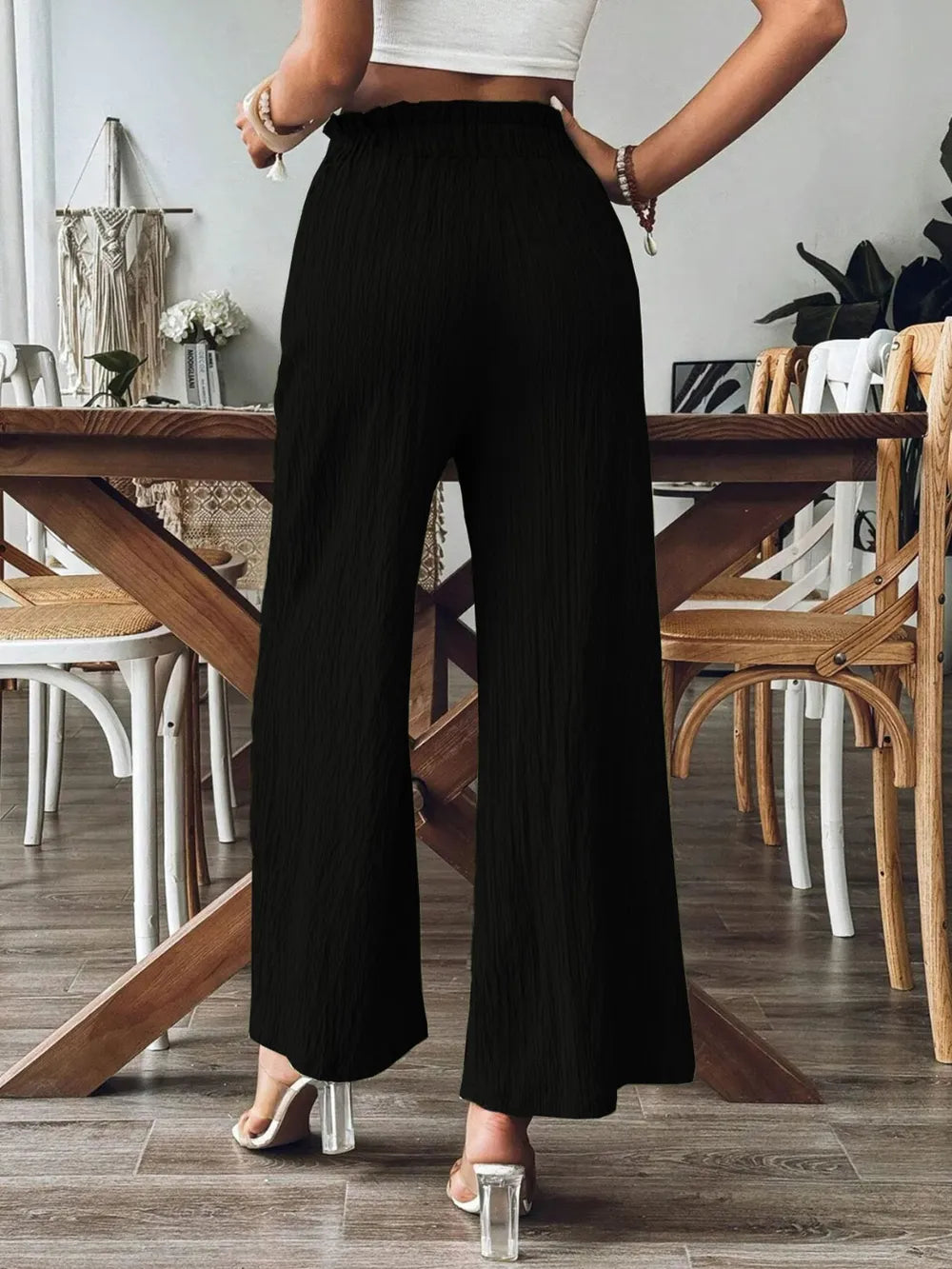 Frill wide-leg pants in black with ruffled elastic waist and wide straight legs