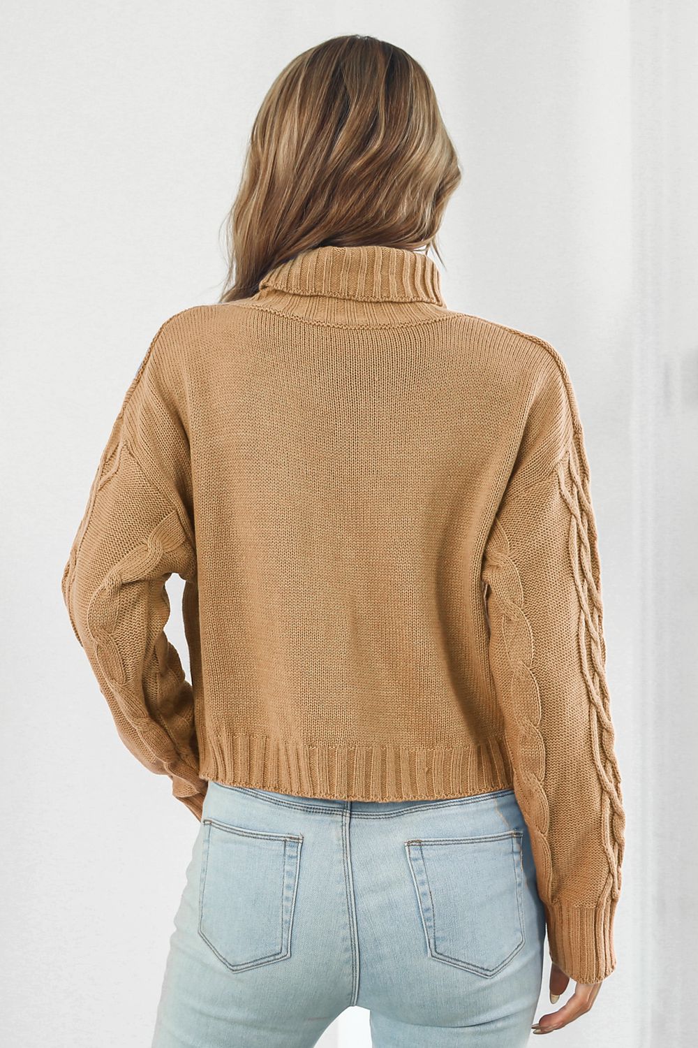 Camel cable-knit turtleneck sweater, back view with dropped shoulders