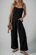 Black smocked spaghetti strap wide-leg jumpsuit with tiered bodice and wide legs